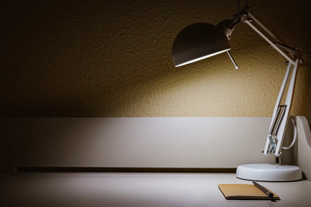 Hrvatski pisac piše za drvenim stolom uz svjetlo lampe